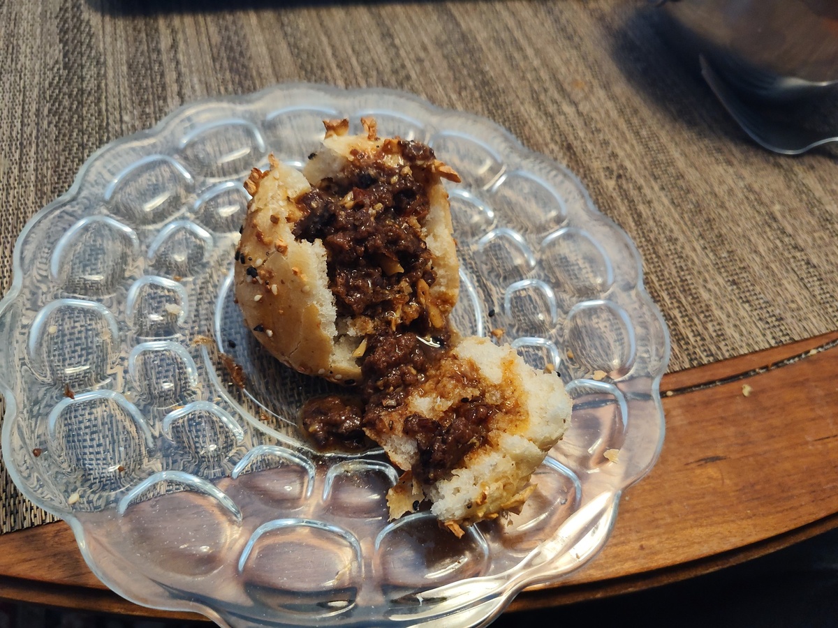 Dinner roll with the middle torn out and covered in spicy bean chili