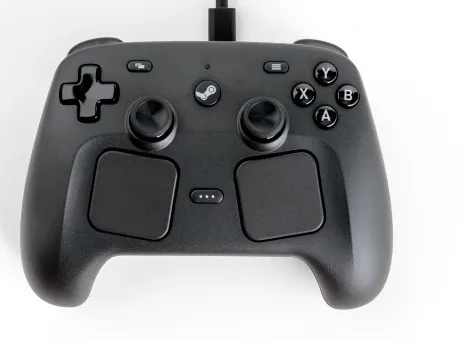 Valve Announces New Steam Machine, Steam Controller and Steam Frame for release in 2026. There is an image of a Steam Controller, which looks like a hybrid between the original Steam Controller and the layout and trackpads of the Steam Deck.