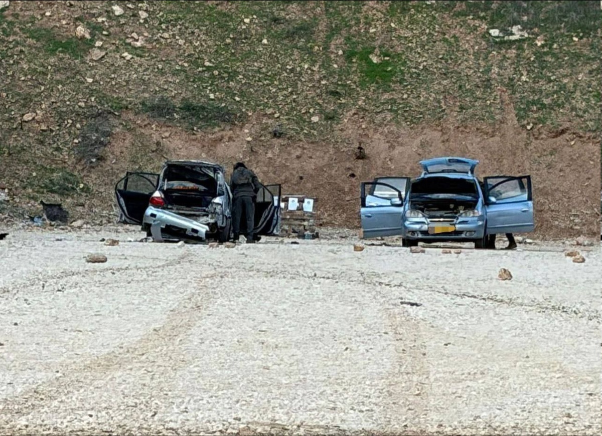 picture of 2 damaged cars on the side of the road