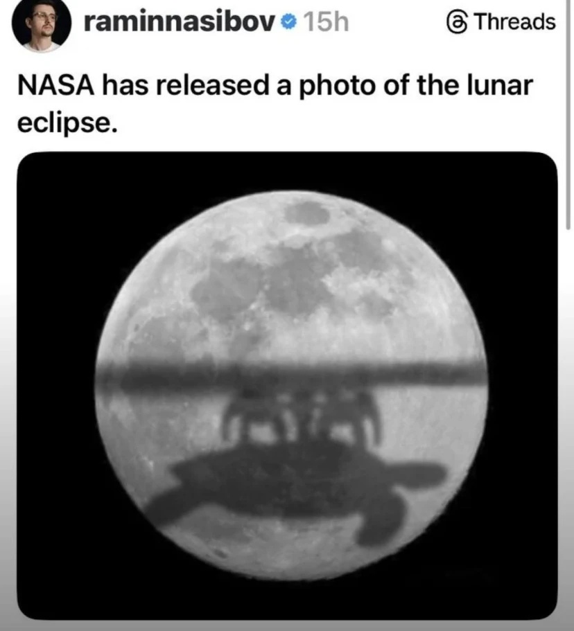 Microblog post: "NASA has released a photo of the lunar eclipse." Picture of the moon with the shadow of a group of robots riding a giant turtle 
